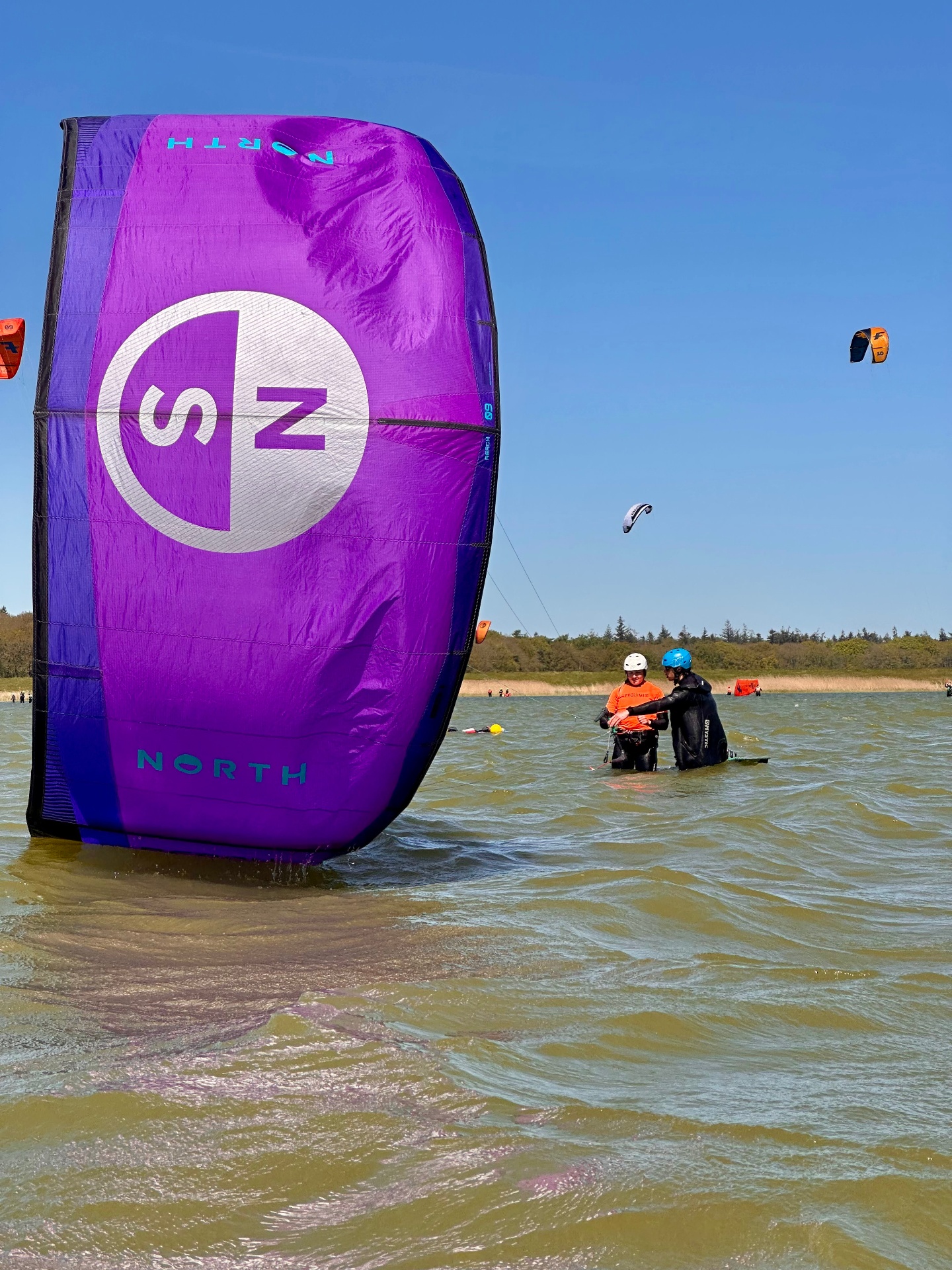 Kitesurfing student riding the board for the first time on flat Essex water