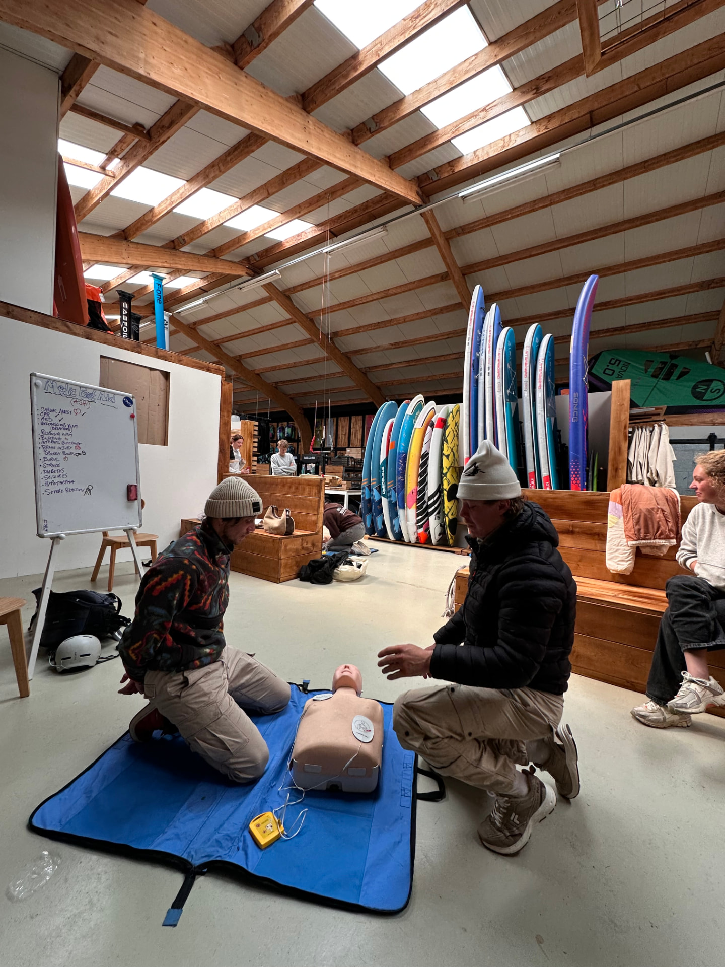 Instructor coaching a candidate through CPR and AED practice on a manikin