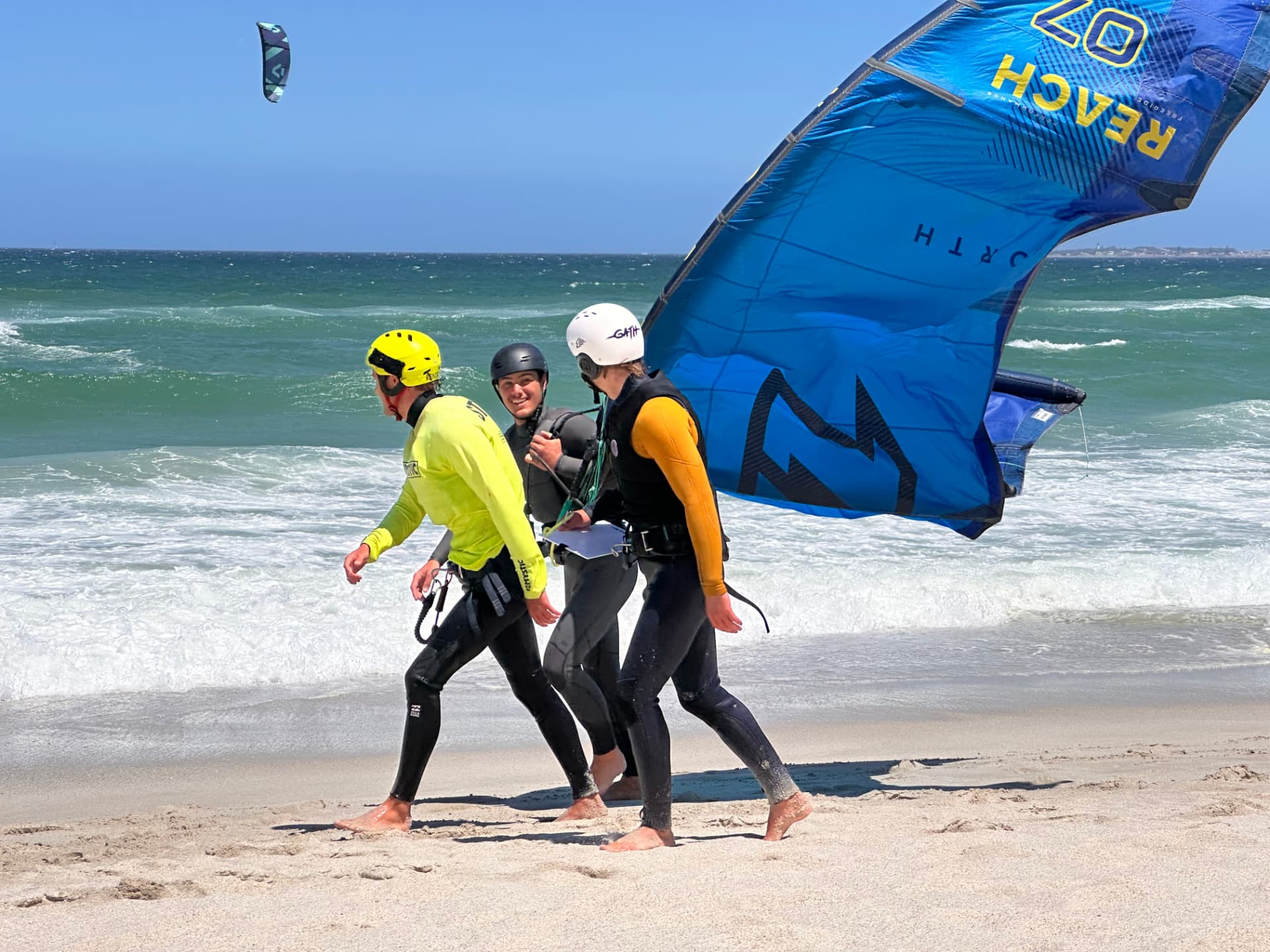 IKO Assistant Course candidates walking out to the water with a kite