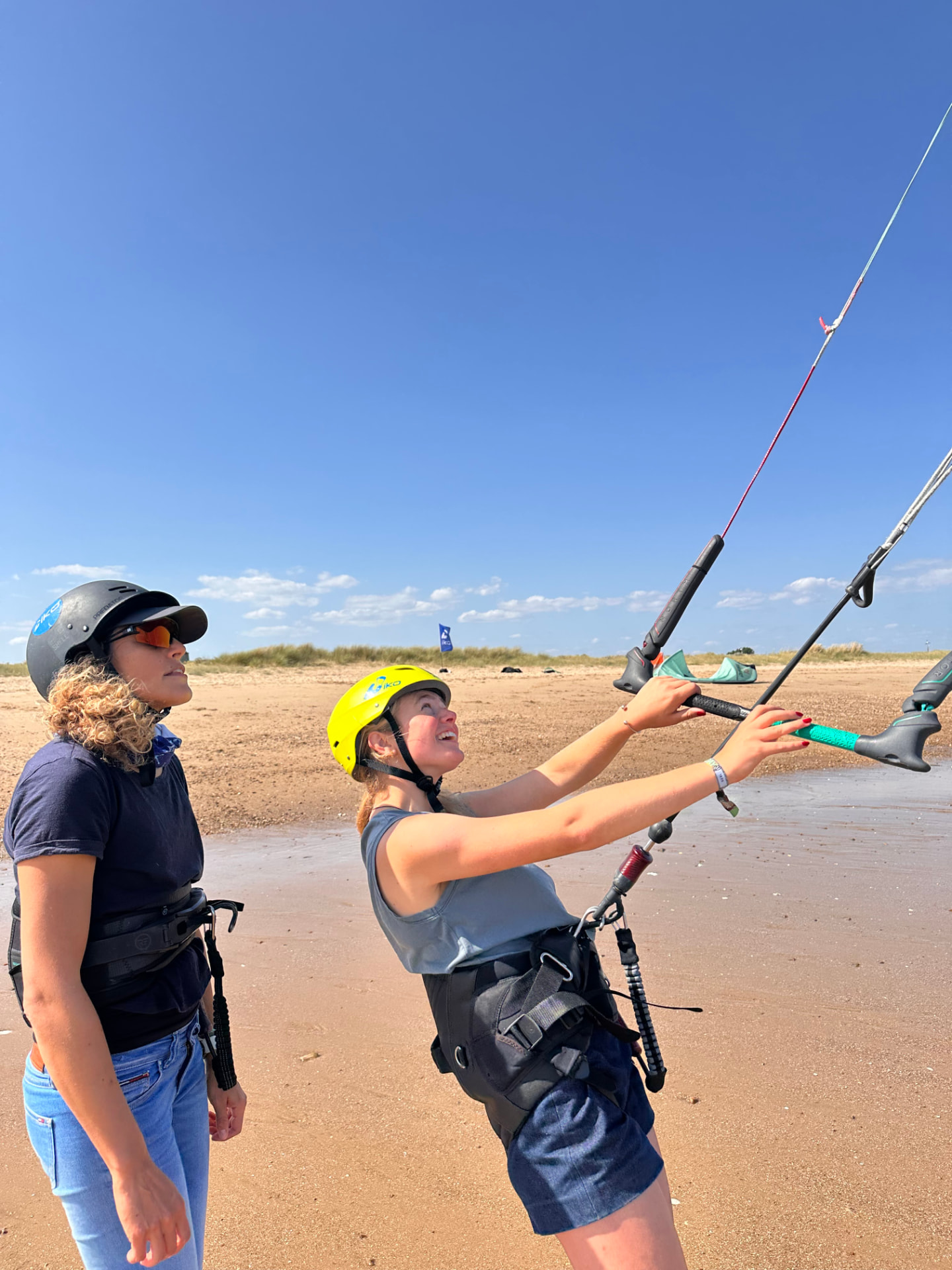 Assistant Course candidate helping a student fly a kite on the beach